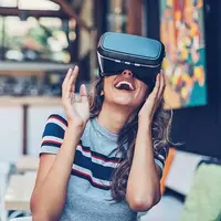 A smiley young woman using VR goggles